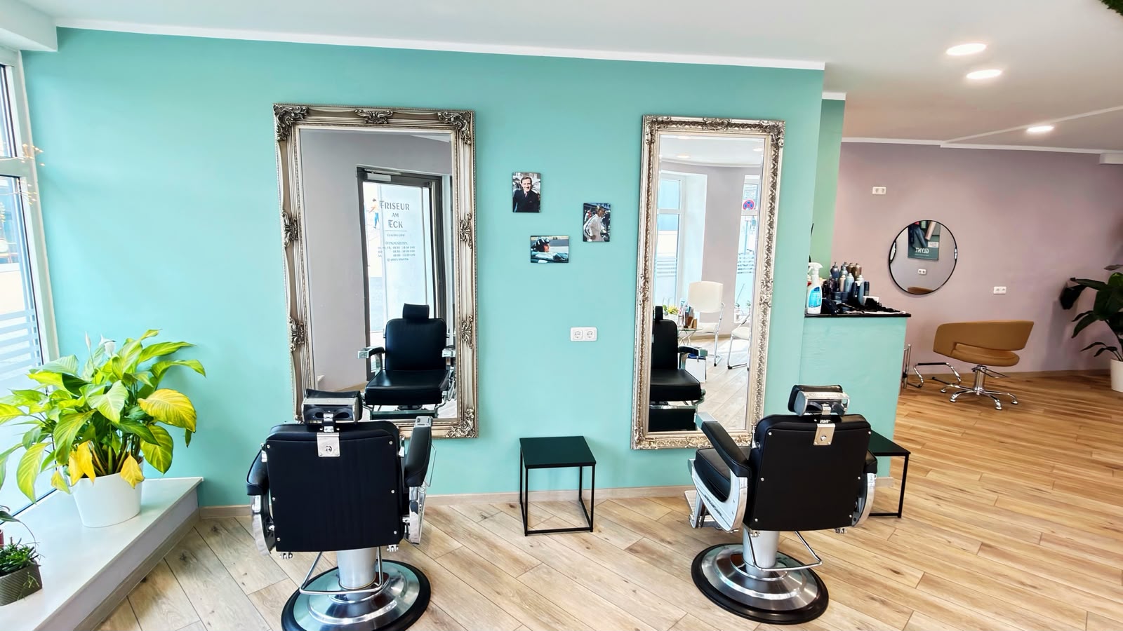 Friseurplätze vor hohen Spiegeln an türkisfarbener Wand