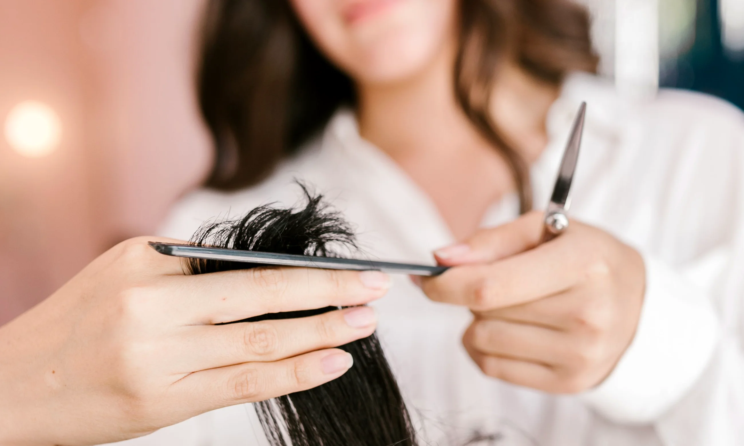 Nahaufnahme: Haare werden konzentriert mit Kamm und Schere geschnitten